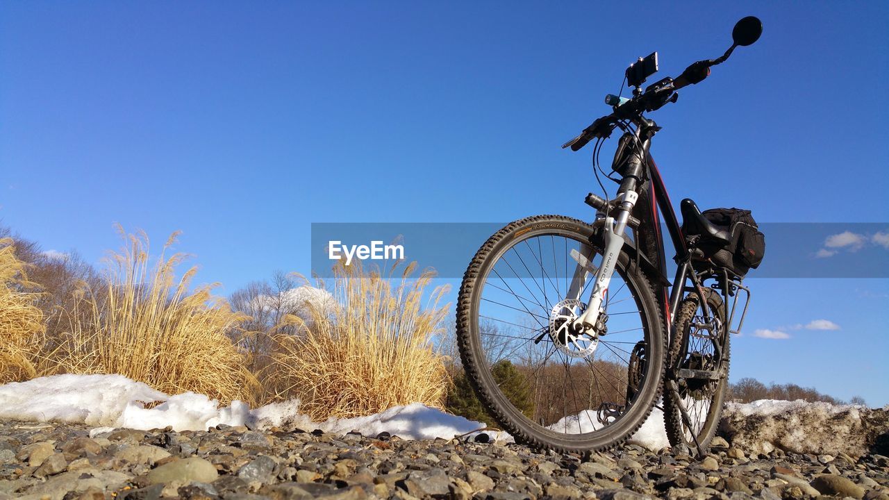 BICYCLE ON SNOW FIELD AGAINST CLEAR BLUE SKY