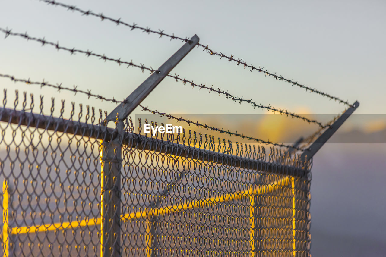 CLOSE-UP OF BARBED WIRE AGAINST SKY