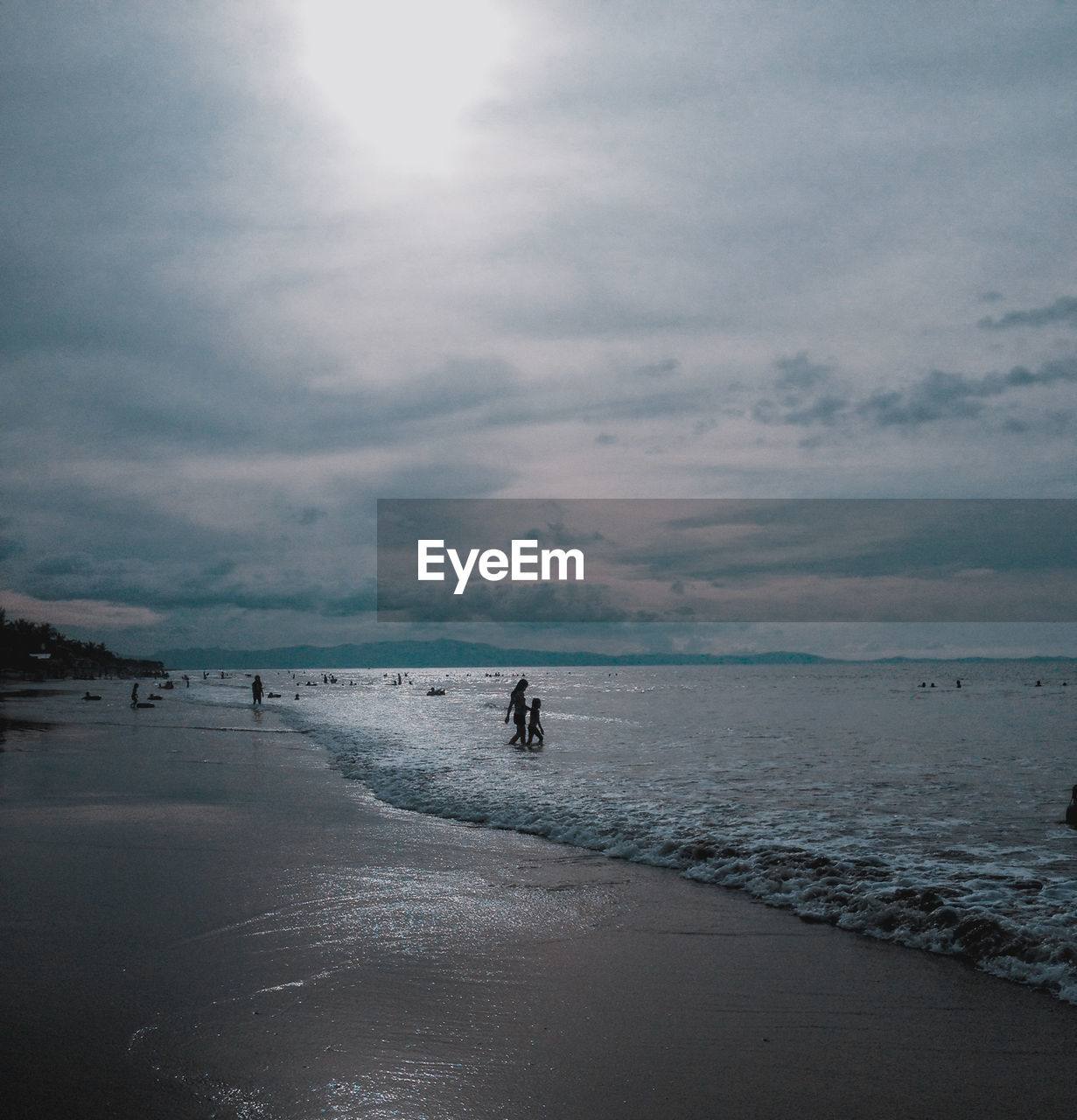 People at beach against sky