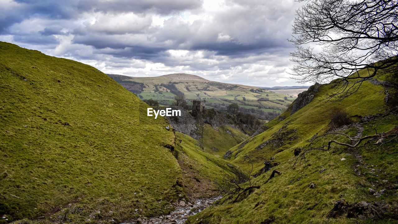 scenic view of mountains against cloudy sky