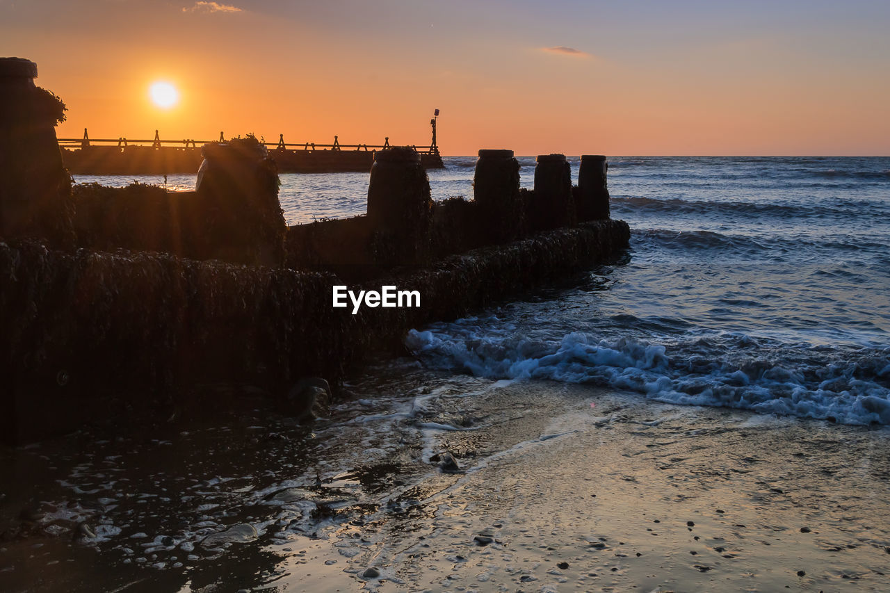 SCENIC VIEW OF SEA AGAINST ORANGE SKY