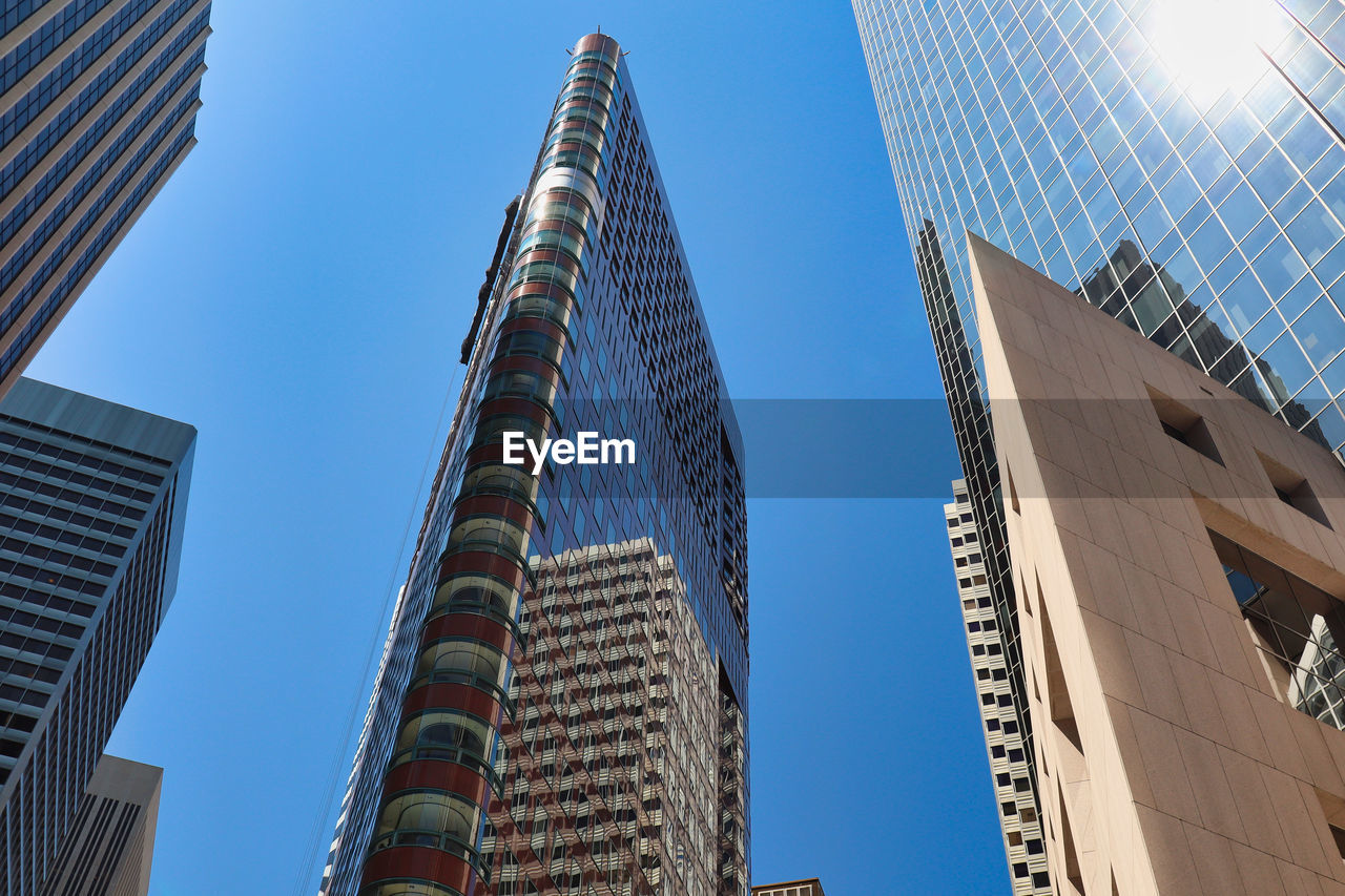 LOW ANGLE VIEW OF MODERN BUILDINGS AGAINST BLUE SKY