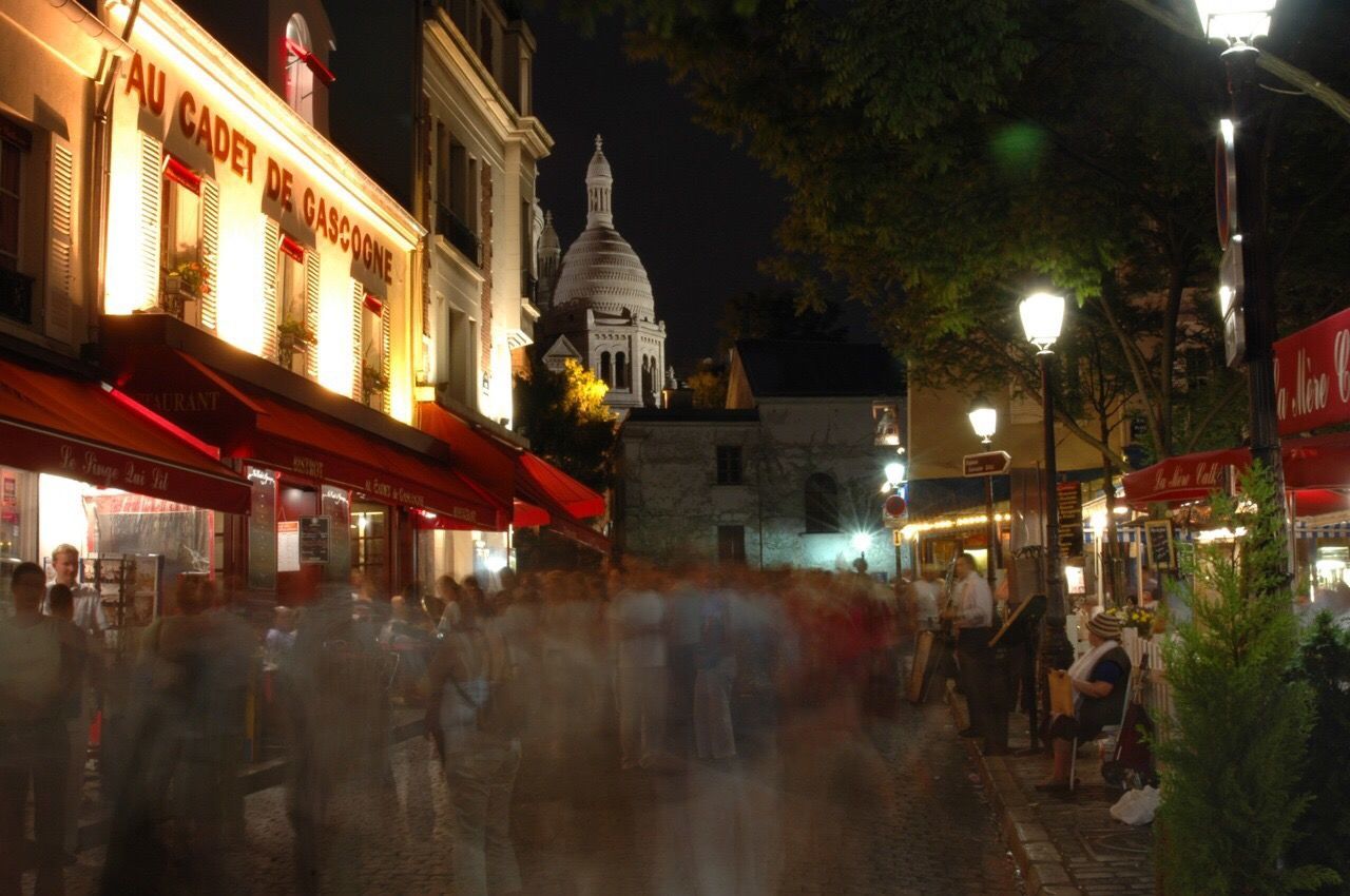 PEOPLE IN ILLUMINATED CITY AT NIGHT