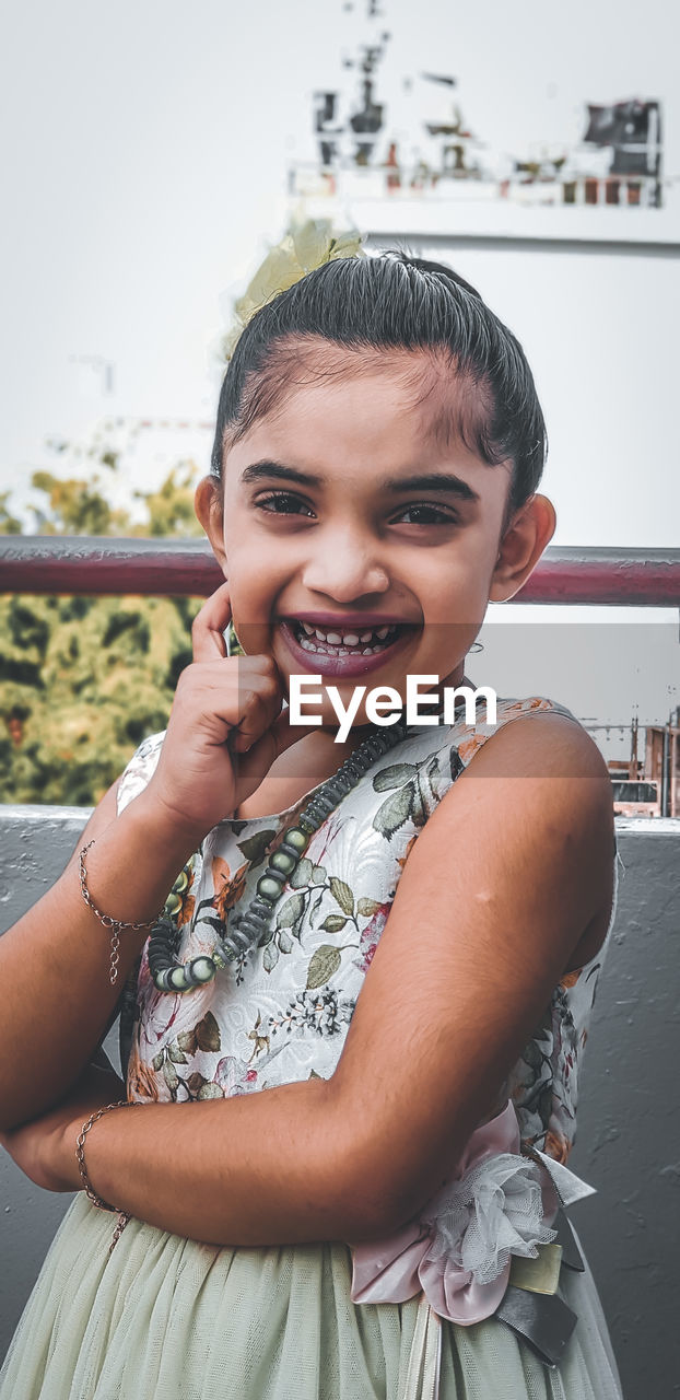 Portrait of smiling girl sitting outdoors