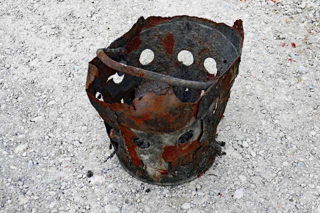 Close-up of rusty bucket on ground