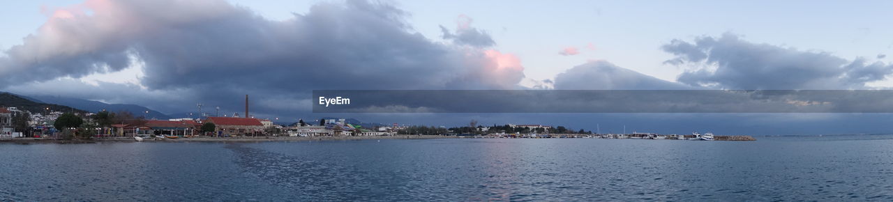 PANORAMIC VIEW OF SEA BY BUILDINGS AGAINST SKY