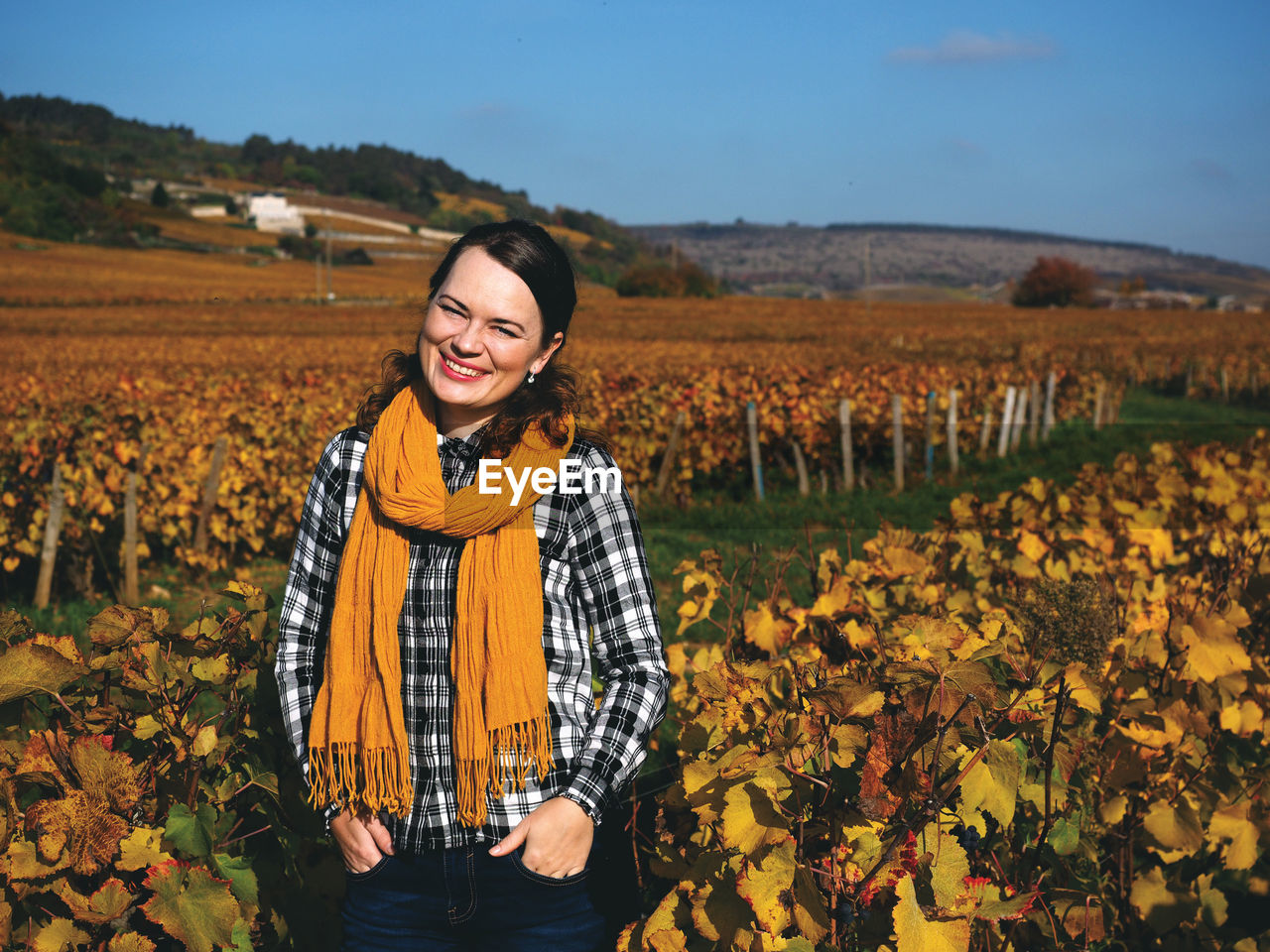 Portrait of smiling woman standing in vineyard