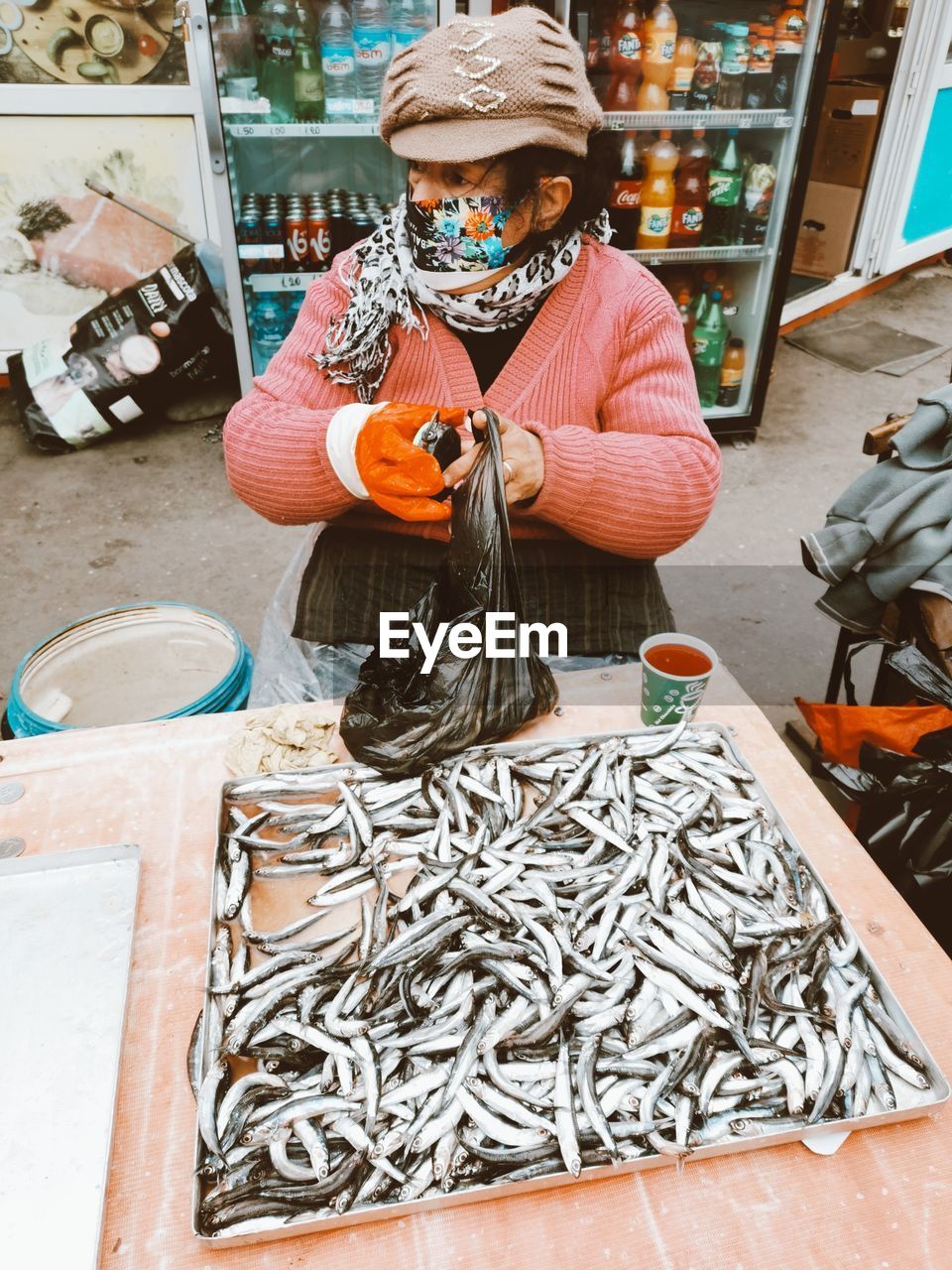 Woman holding fish for sale at market