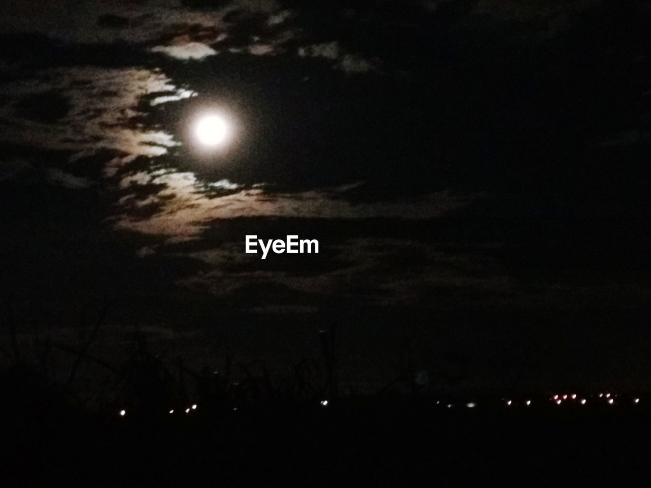 LOW ANGLE VIEW OF ILLUMINATED MOON AGAINST SKY AT NIGHT