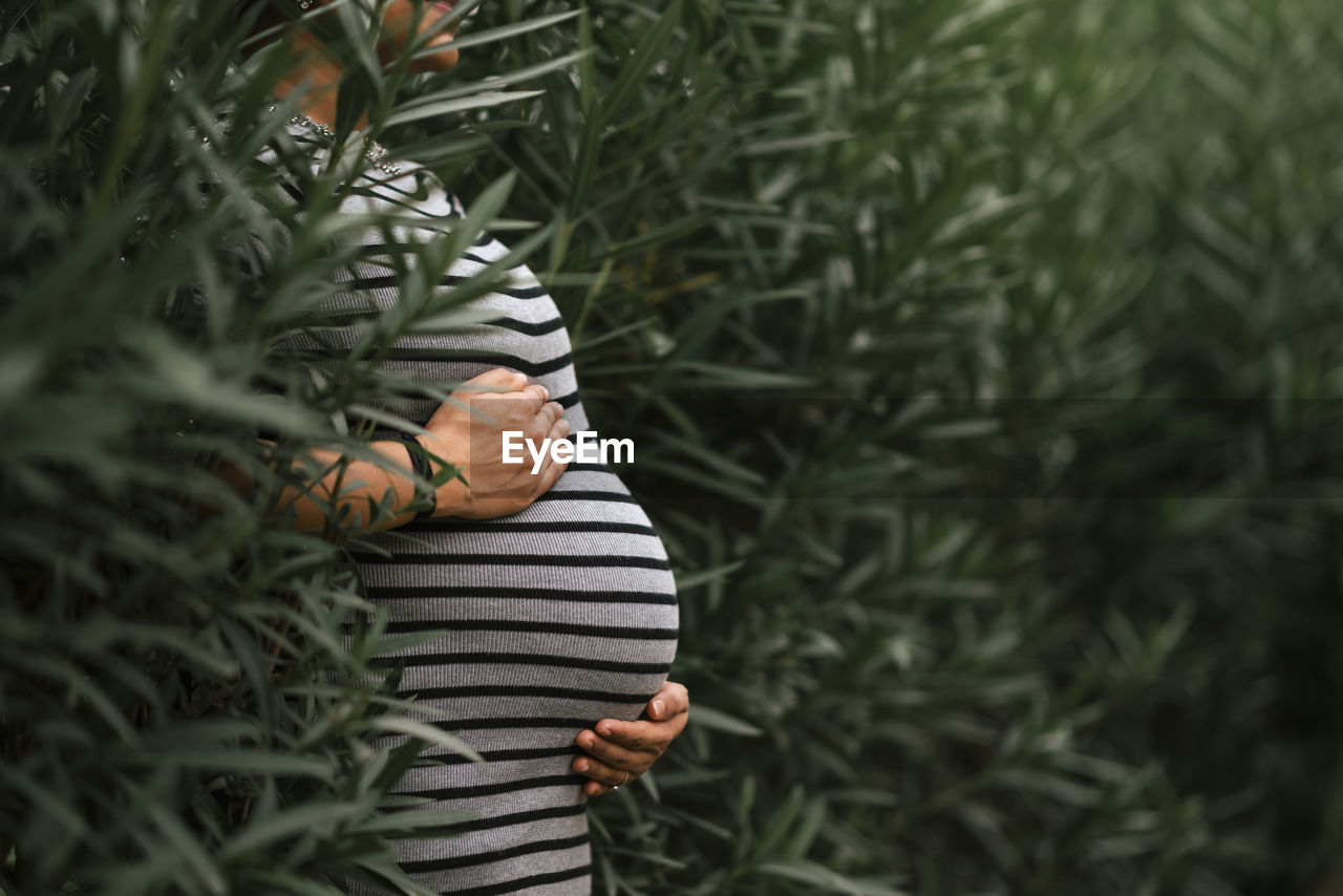 Low section of woman standing by plants