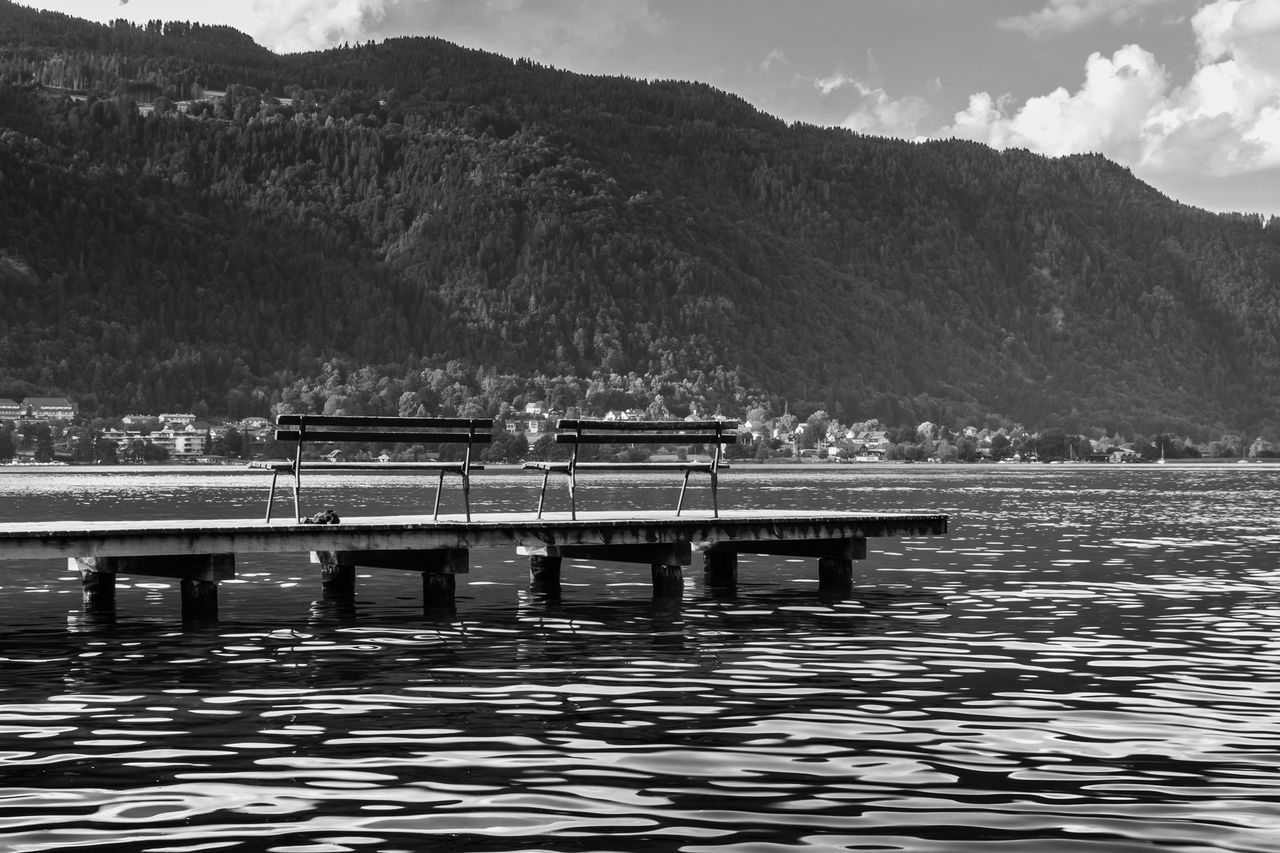 PIER OVER LAKE AGAINST MOUNTAIN RANGE