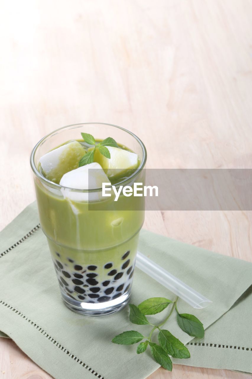 CLOSE-UP OF DRINK SERVED ON TABLE IN GLASS