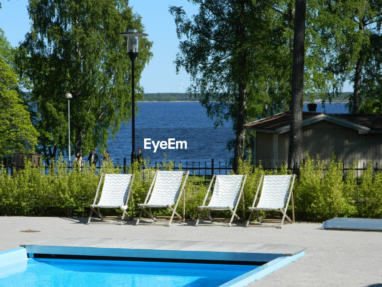 Swimming pool by trees against clear sky