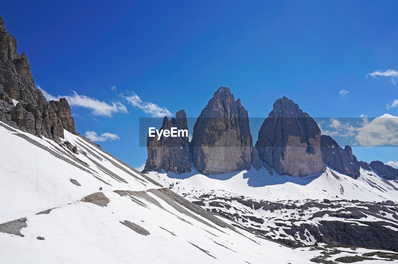 Tre cime di lavaredo on a sunny day in june, still a lot of snow on the ground.