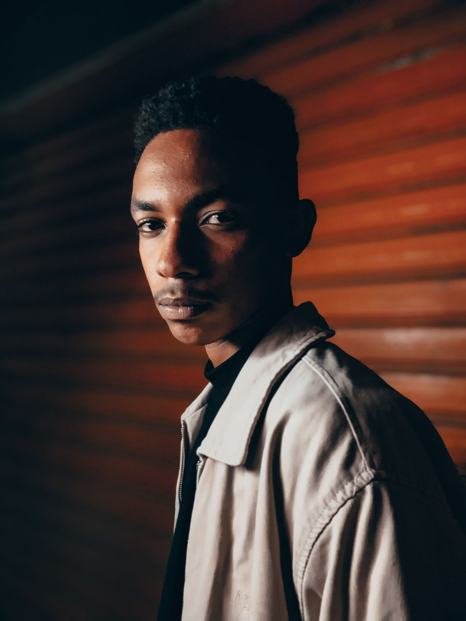 Portrait of young man standing against wall