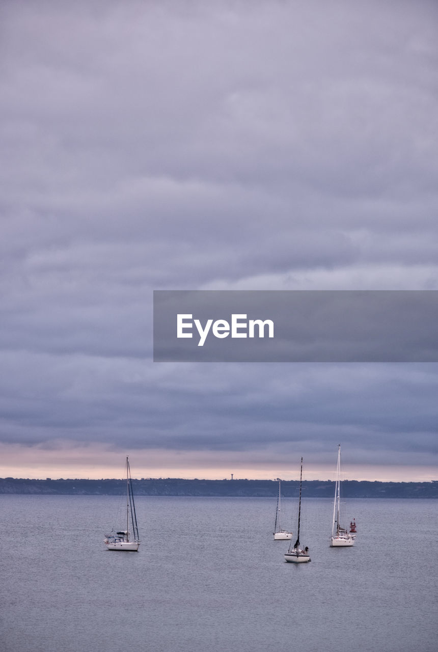 SAILBOAT SAILING IN SEA AGAINST SKY