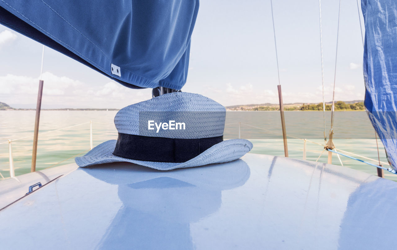 LOW SECTION OF MAN ON SAILBOAT SAILING IN SEA