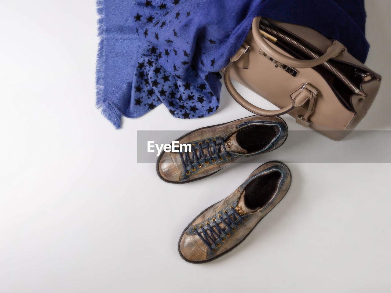 High angle view of shoes with purse and scarf on white background