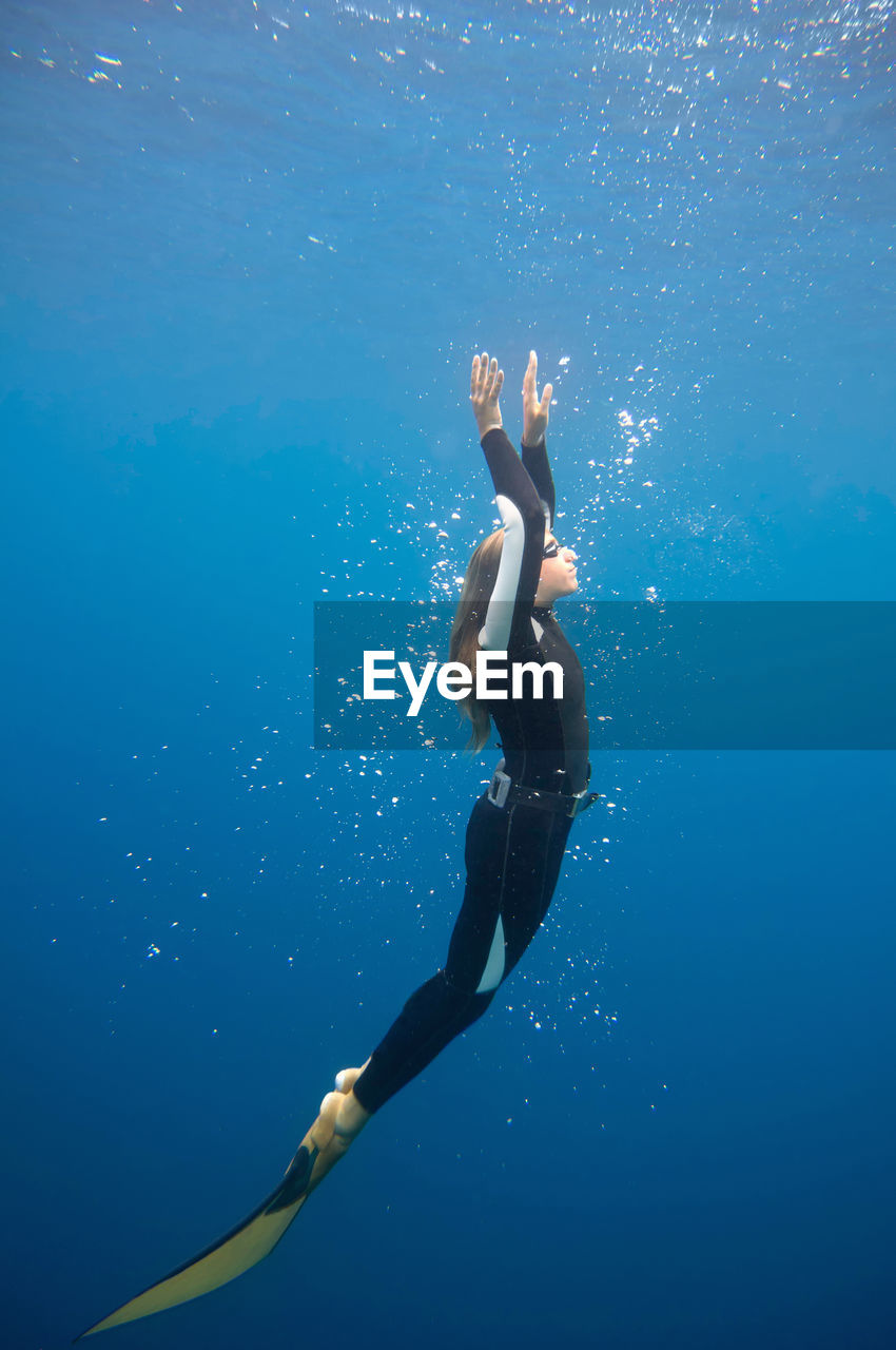 Mid adult woman swimming undersea