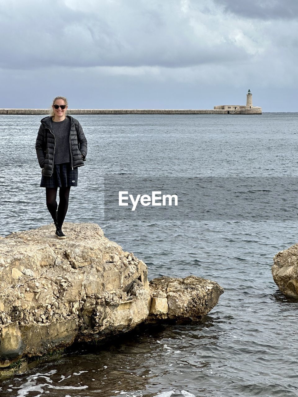 water, shore, one person, sea, sky, coast, cloud, full length, nature, adult, rock, ocean, land, men, beach, beauty in nature, standing, scenics - nature, environment, day, overcast, front view, outdoors, body of water, holiday, leisure activity, landscape, wave, vacation, clothing, tranquility, trip, bay, lifestyles, travel, horizon over water, motion, portrait, horizon, architecture, looking, water's edge, tranquil scene, mature adult, copy space