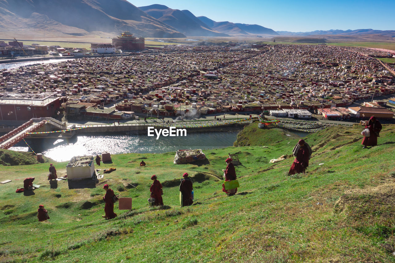Monks walking on landscape against townscape