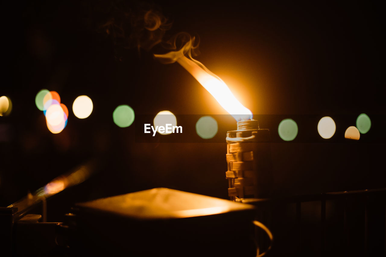 Close-up of lit candles in dark