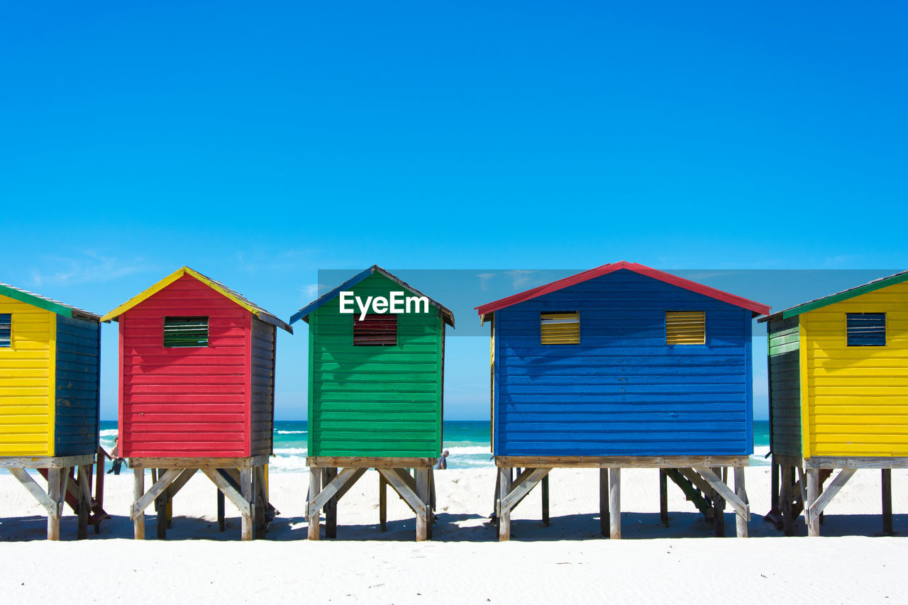 BEACH HUTS AGAINST BLUE SKY