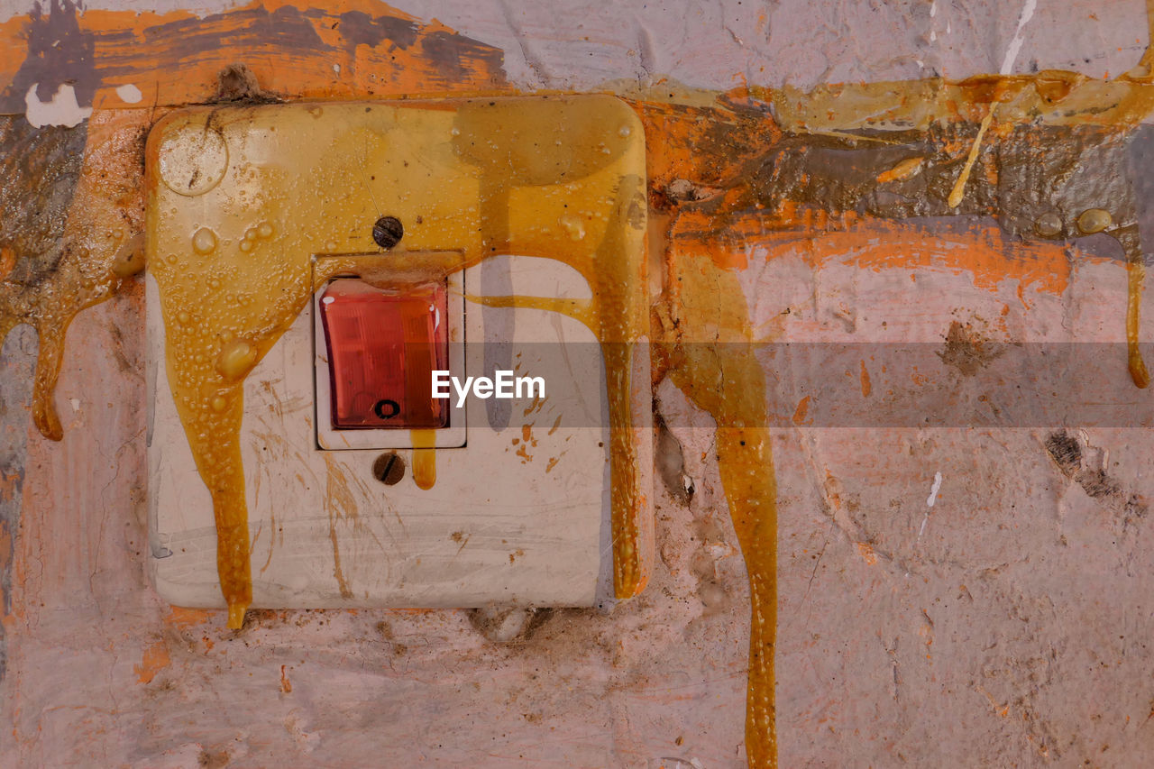 Full frame shot of electricity switch on weathered wall