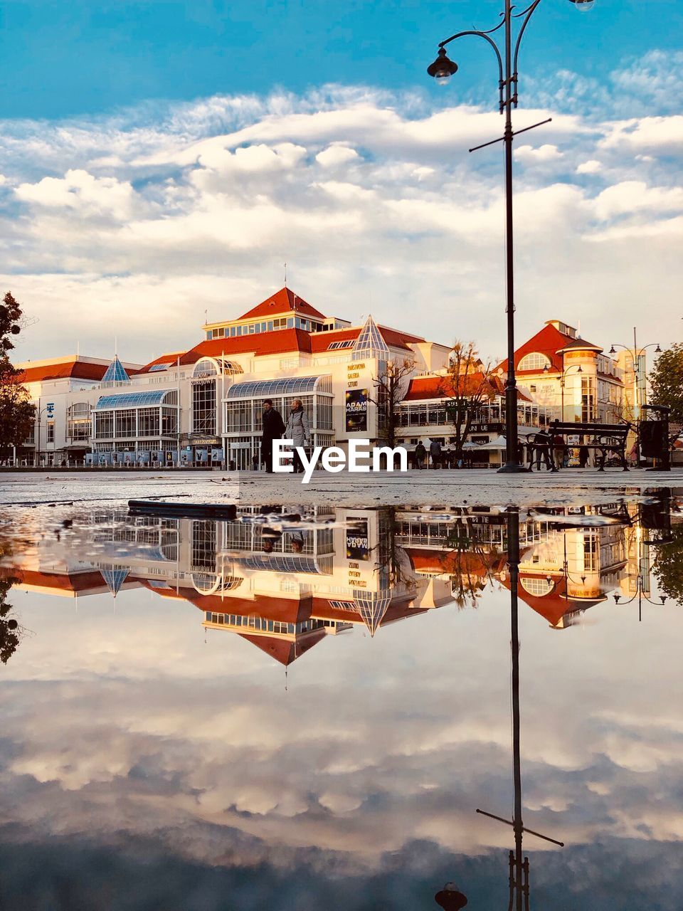 REFLECTION OF BUILDINGS ON LAKE AGAINST SKY