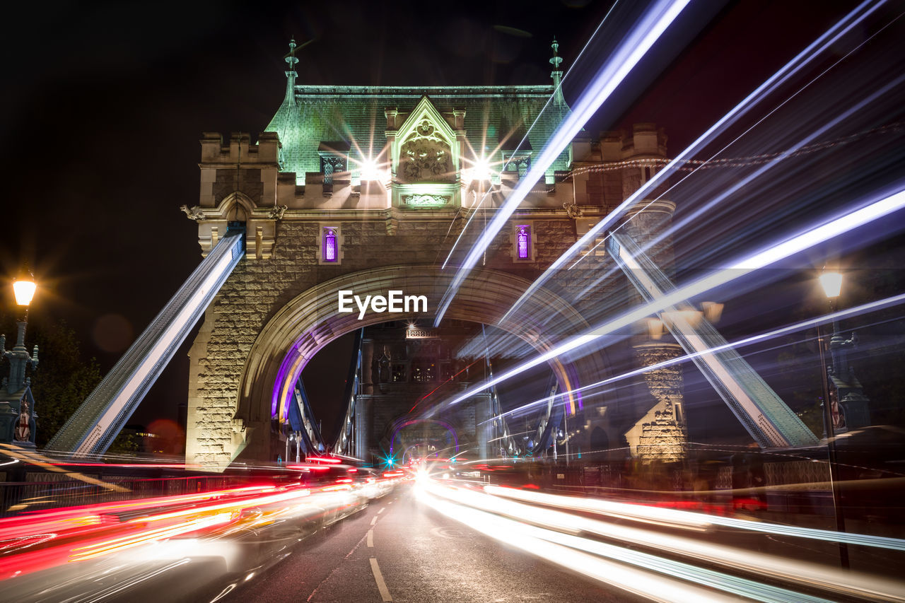 Light trails on bridge in city at night