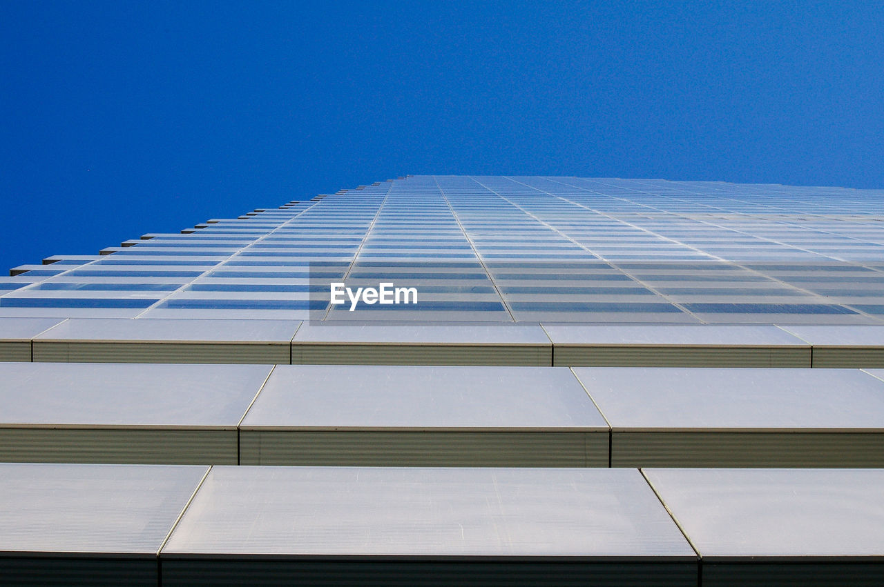Low angle view of office building against blue sky