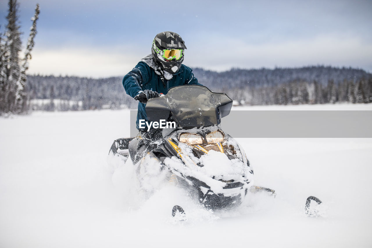 Man riding snowmobile on frozen lake.