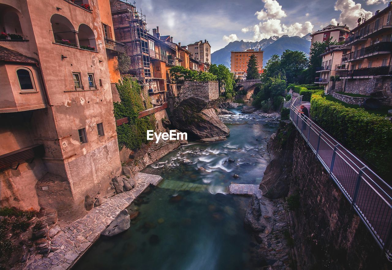 River flowing by building against sky