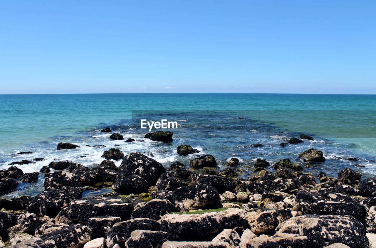 Scenic view of sea against clear blue sky