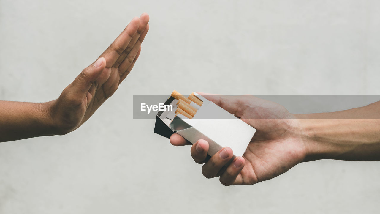 Close up hands of person refusing to smoke cigarette. negative attitude to smoking. quitting smoking