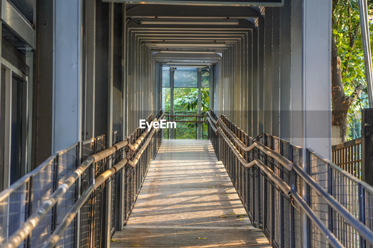 Footbridge over footpath amidst buildings