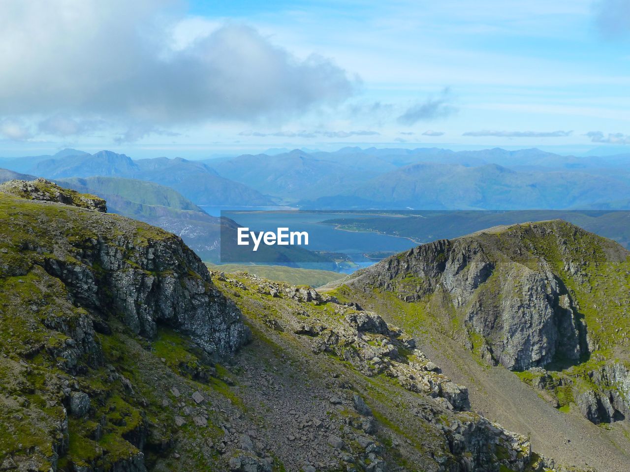 Scenic view of mountains against cloudy sky