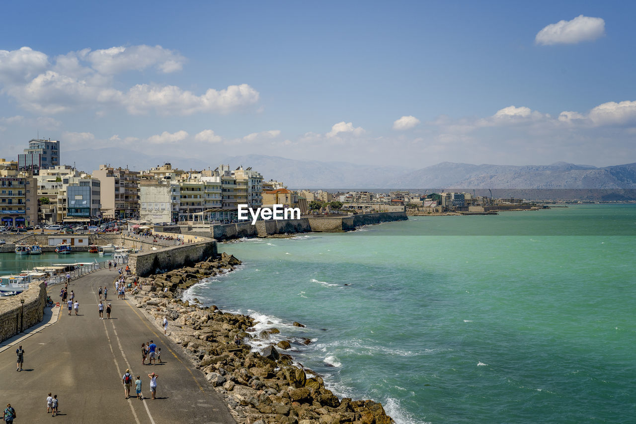 High angle view of sea and buildings against sky