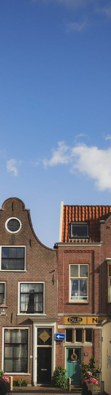 LOW ANGLE VIEW OF RESIDENTIAL BUILDING AGAINST SKY