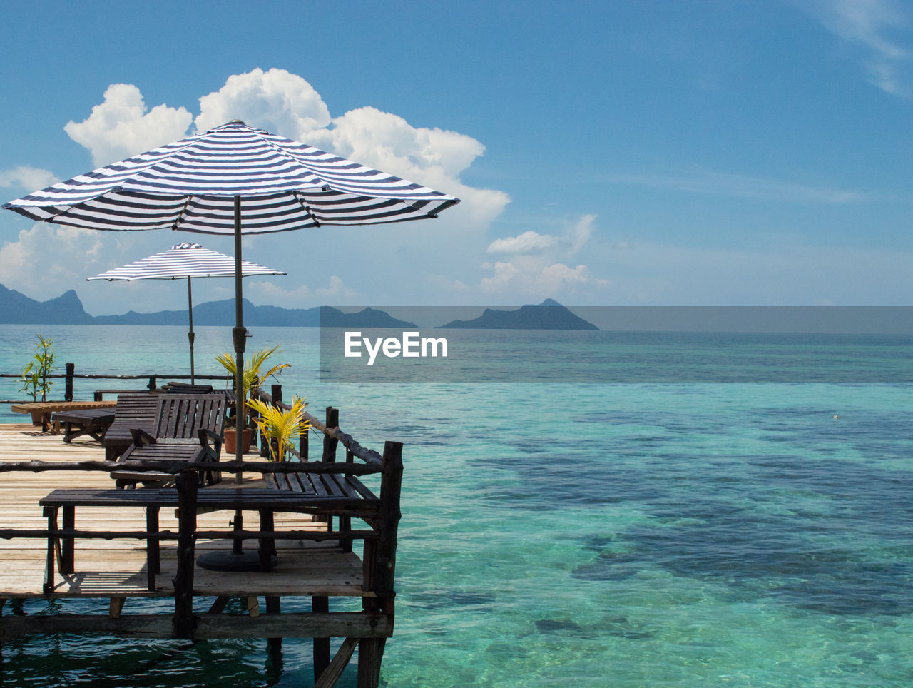 CHAIRS AND TABLE BY SEA AGAINST SKY