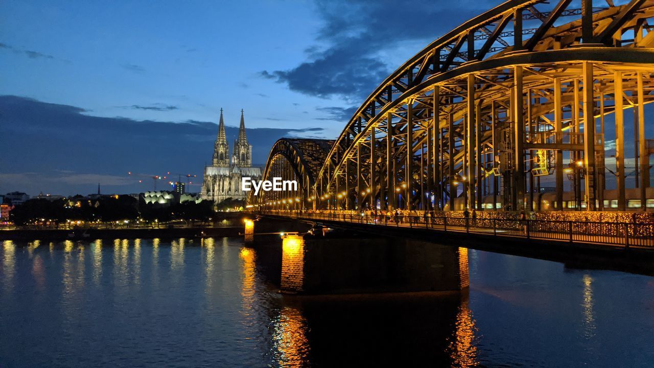 View of bridge over river at night in cologne