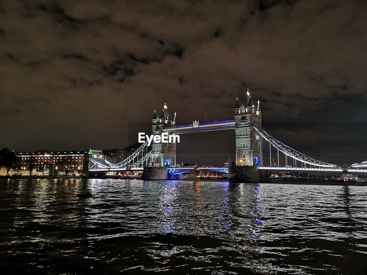 Illuminated bridge over river at night