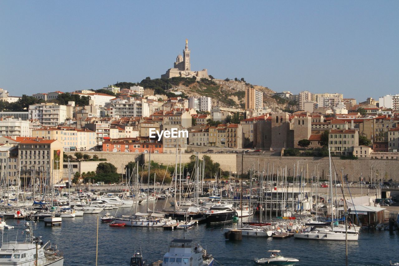 Sailing boats at harbor and church notre-dame de la garde in background