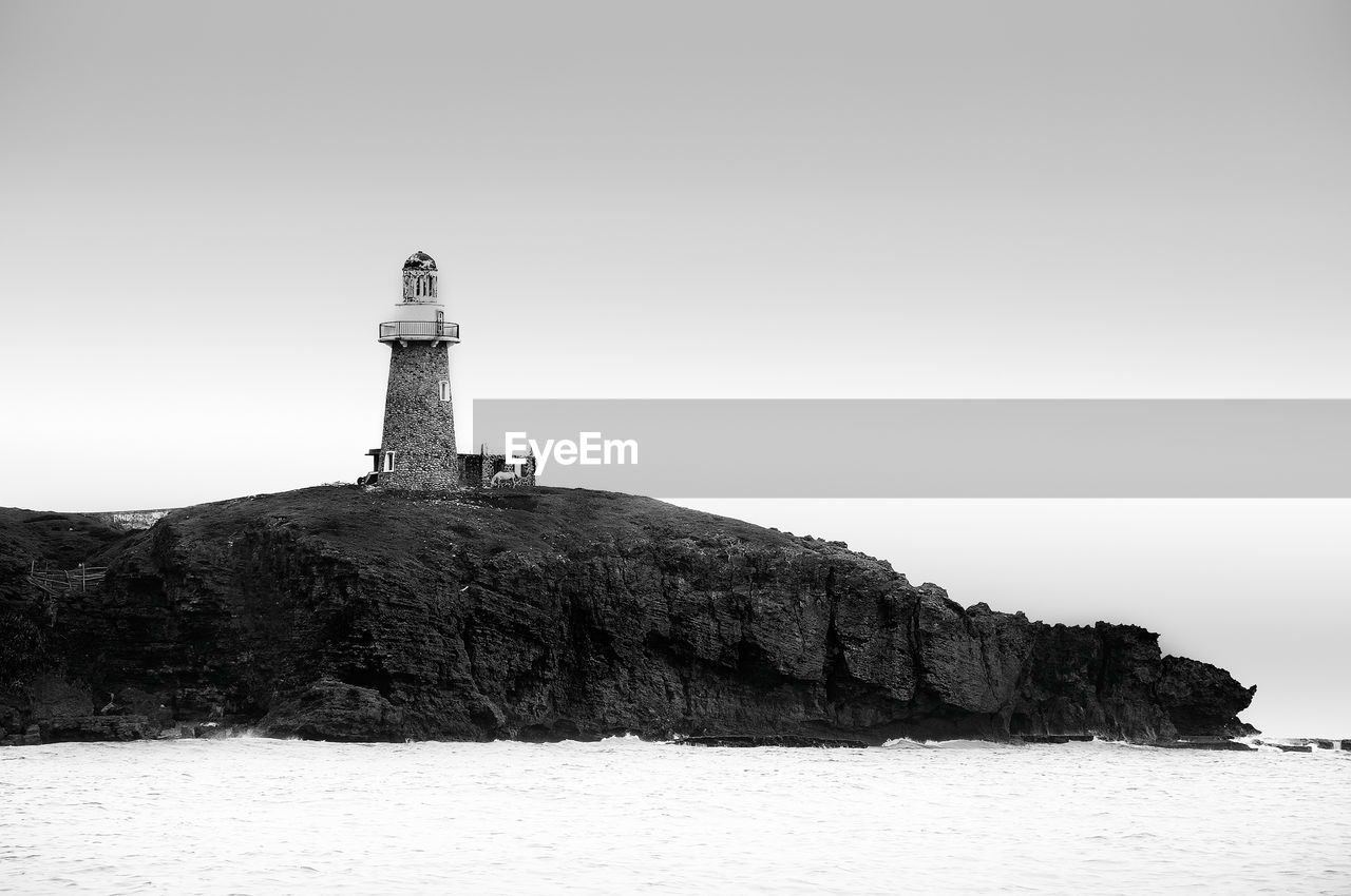 LIGHTHOUSE ON CLIFF AGAINST CLEAR SKY