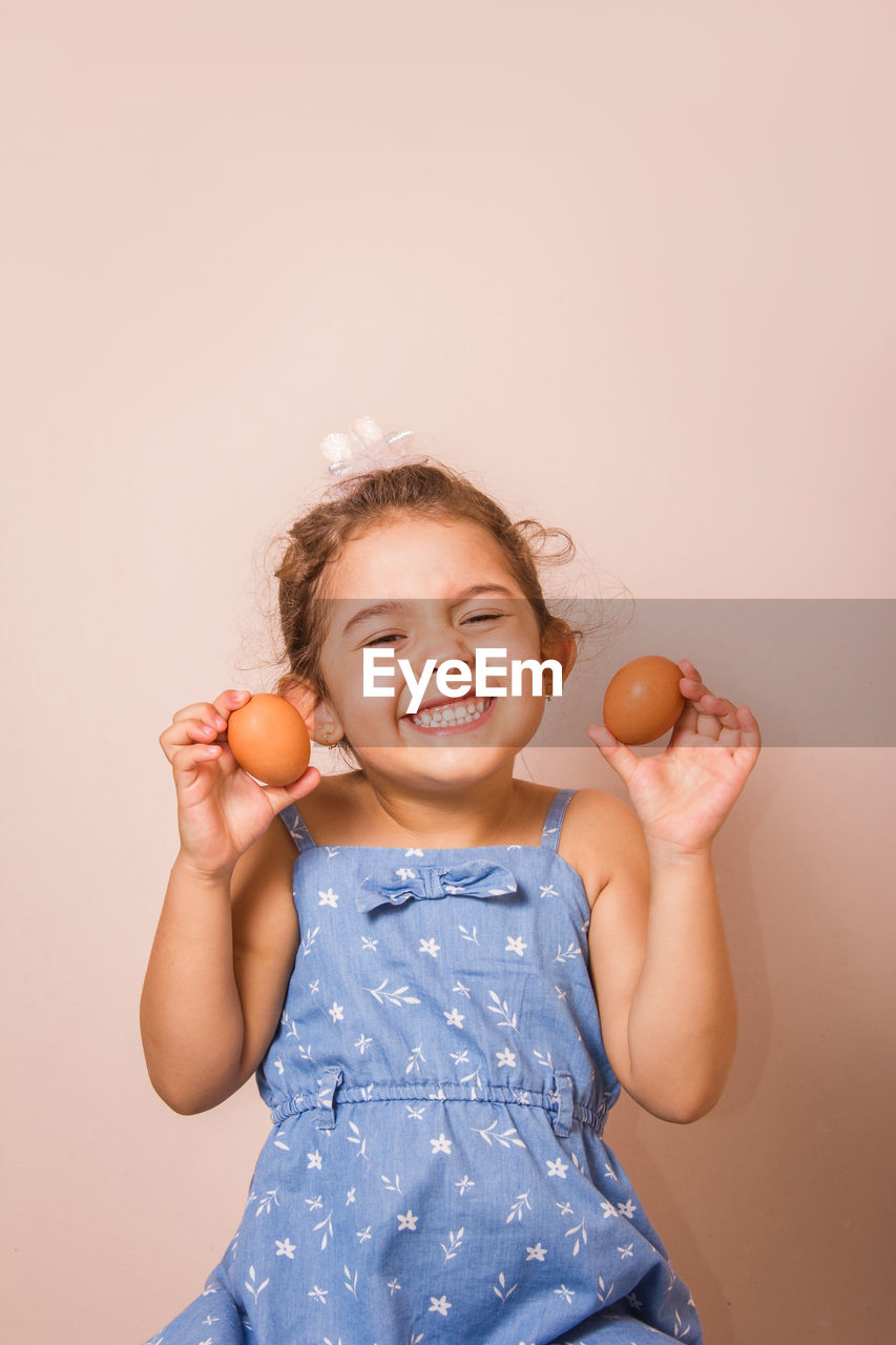 Portrait of smiling girl holding eggs