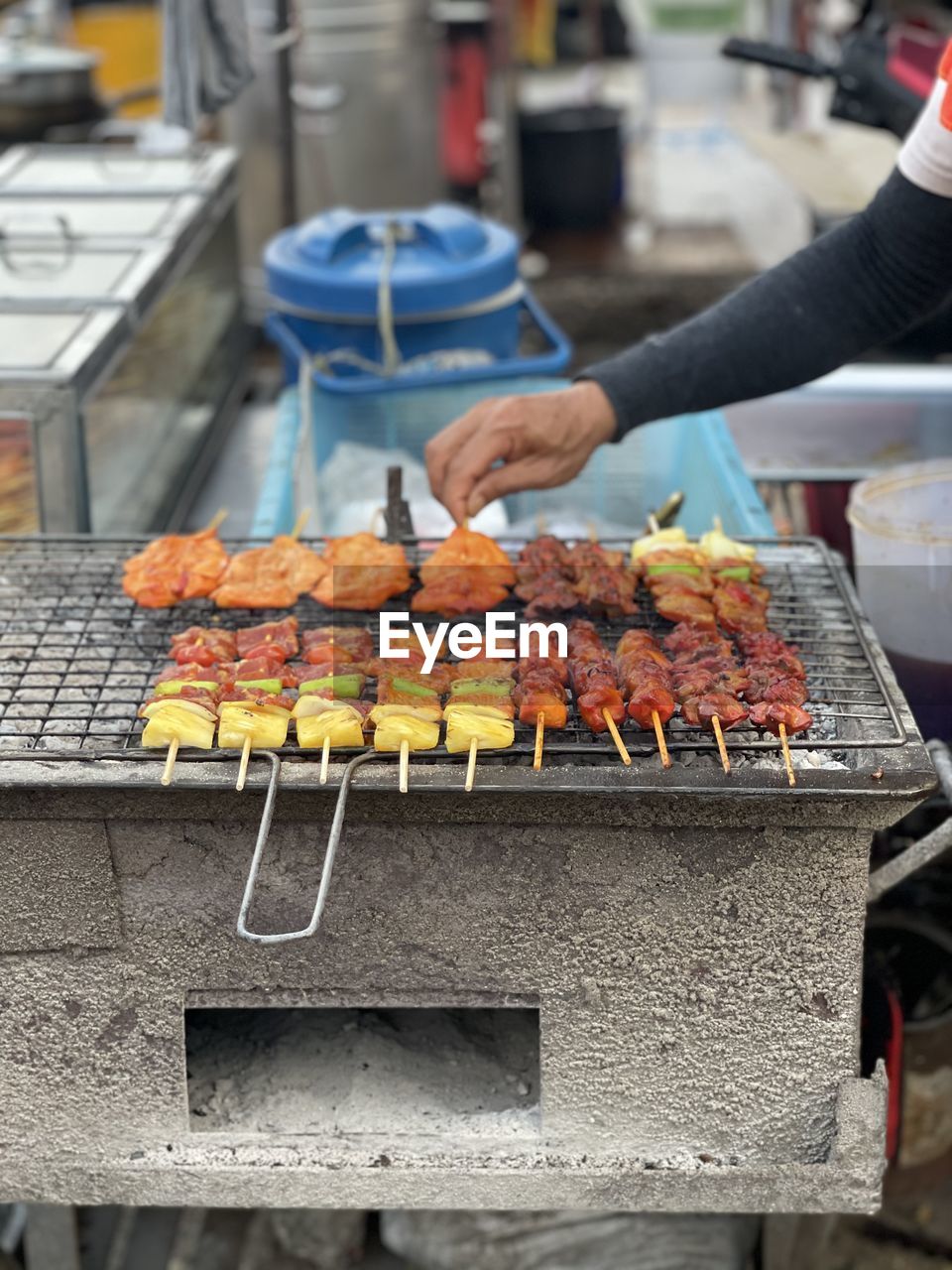 Person preparing food on barbecue grill