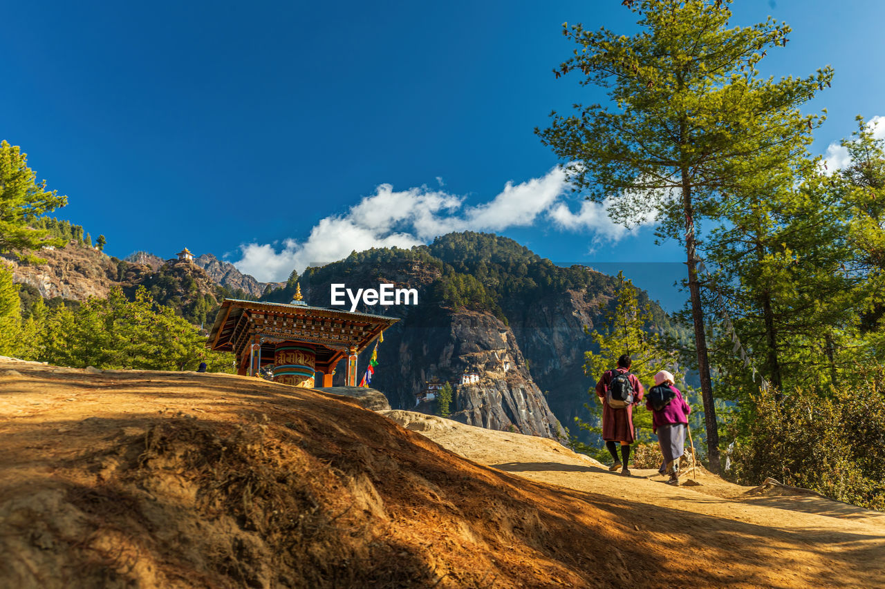 REAR VIEW OF PEOPLE WALKING ON MOUNTAIN