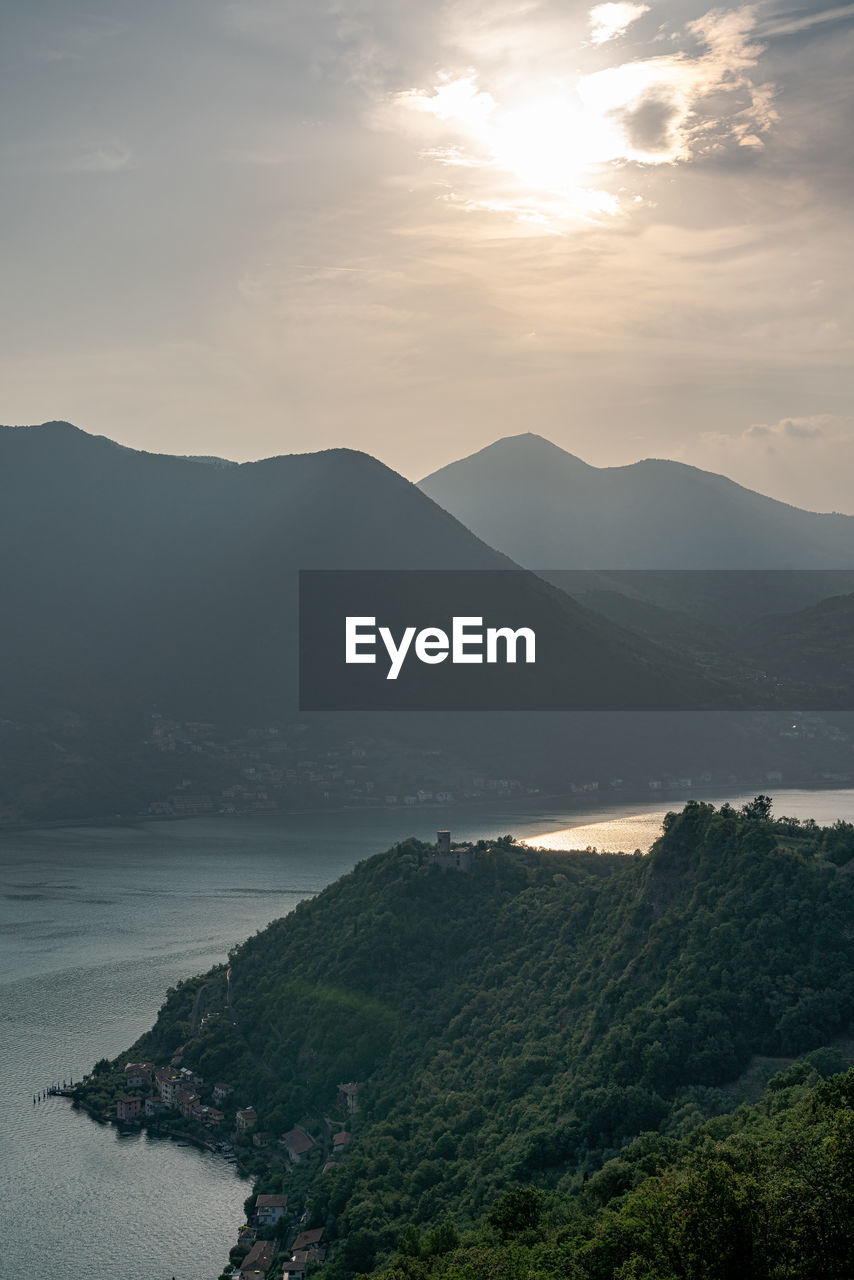 Scenic view of sea and mountains against sky during sunset