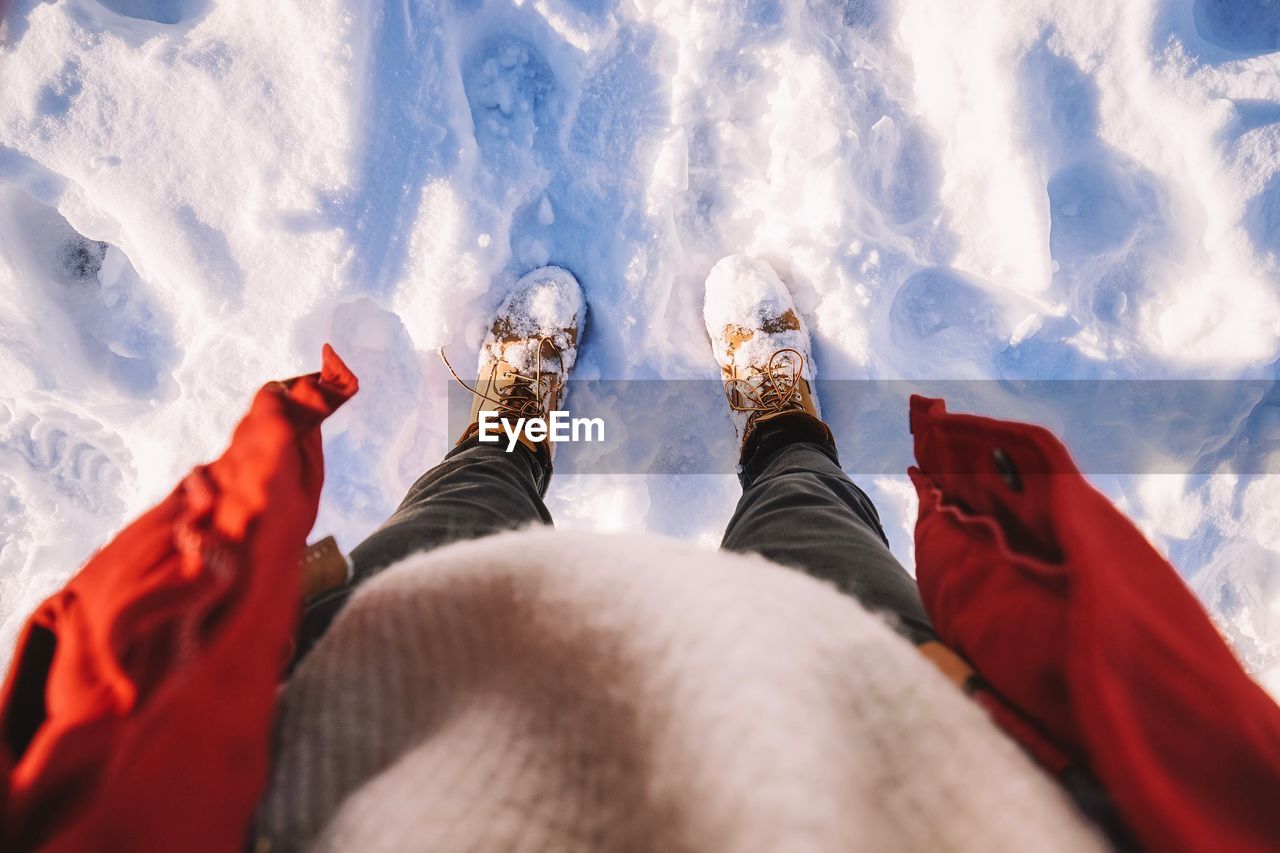 Low section of person standing on snow