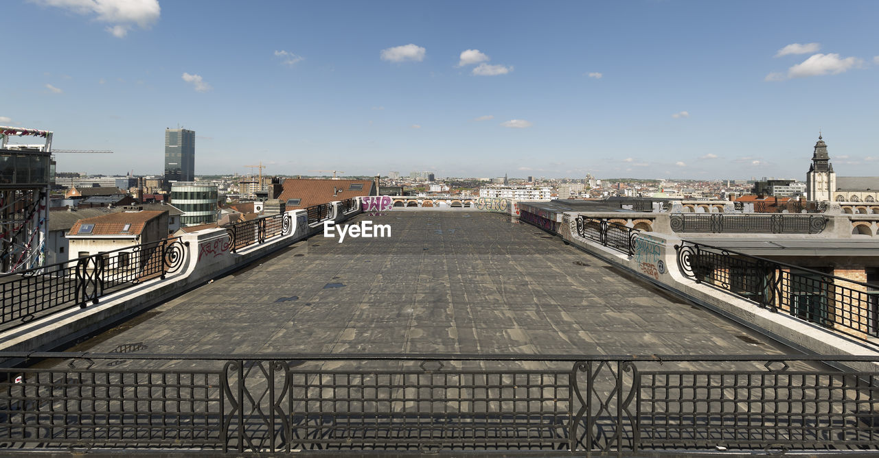 BRIDGE OVER RIVER BY BUILDINGS AGAINST SKY IN CITY